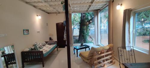 uma sala de estar com um sofá e uma janela em The Sunshine Bungalow em Bangalore