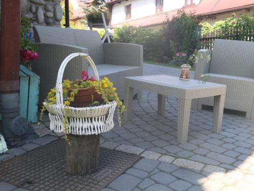 a patio with a table and a basket of flowers at Smyrecek-centrum Bukowiny in Bukowina Tatrzańska