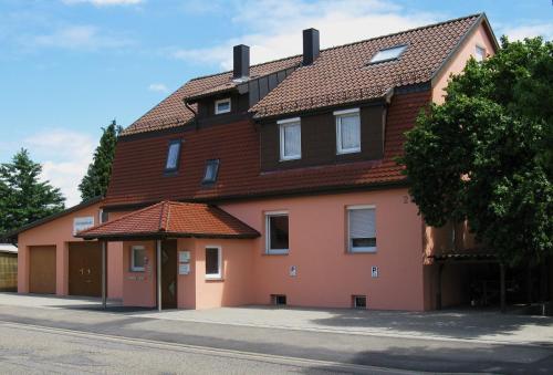 a large orange building with a brown roof at Gästeapartments Haus Kohler in Abstatt