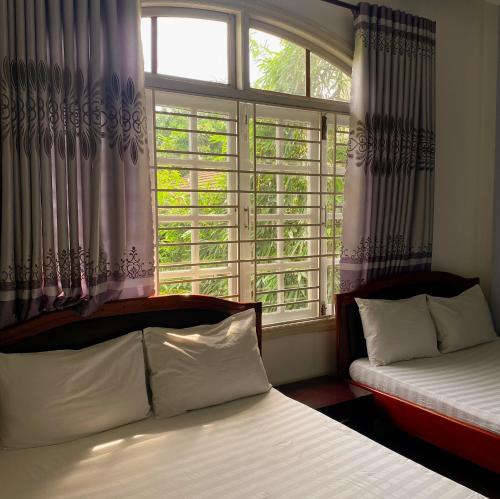 a bedroom with two beds in front of a window at Salyna Motel in Da Nang