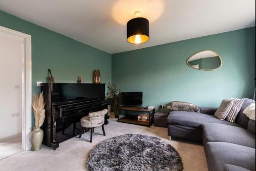 een woonkamer met een bank en een piano bij Charming 2 Bed Home in Edwalton in Nottingham