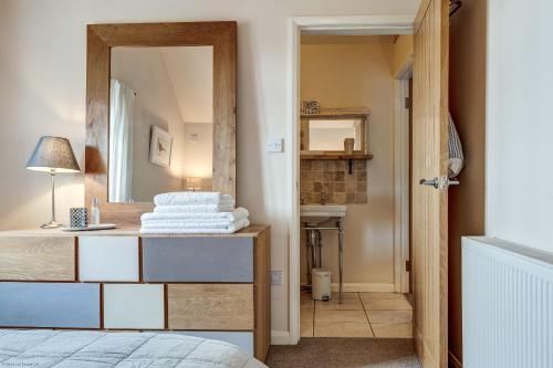 a bedroom with a mirror on a dresser and a bed at Sansoms Loft in Woodstock