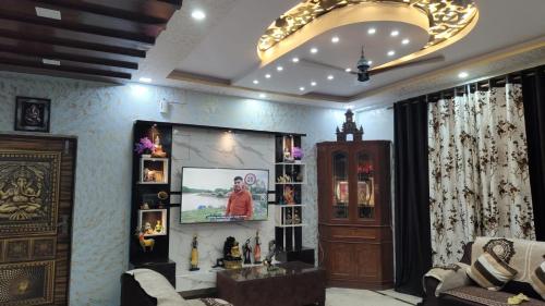 a living room with a couch and a tv on a wall at Luxurious 3 BHK Flat in Ghaziabad in Ghaziabad