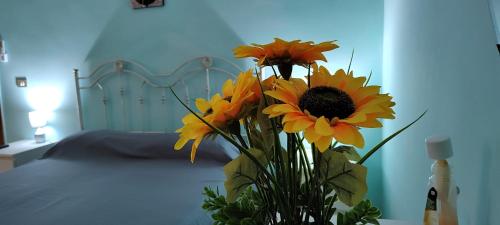 a bouquet of sunflowers in a vase on a bed at Il Girasole in Rutigliano
