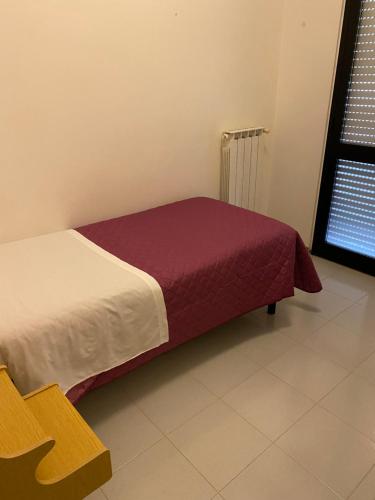 1 dormitorio con 1 cama con manta roja en Hotel Ferrara, en Chianciano Terme