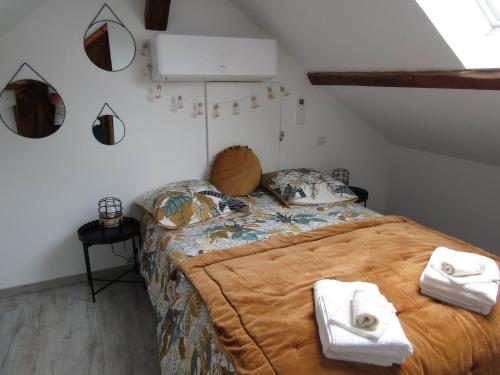 une chambre avec un lit avec des serviettes dessus dans l'établissement Chez Biquet, à Cercy-la-Tour