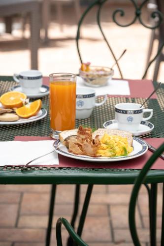 a table with a plate of breakfast food and orange juice at Hotel San Marco in Gubbio