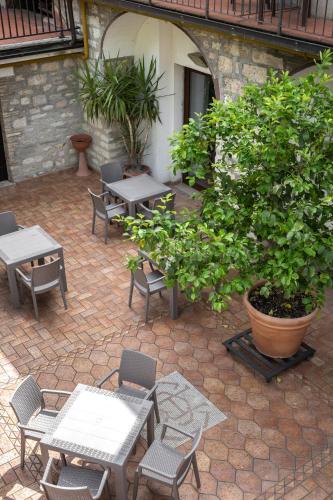 a patio with tables and chairs and a tree at Hotel San Marco in Gubbio