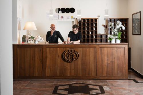 two men sitting at a counter in a bar at Hotel San Marco in Gubbio