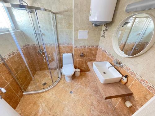 a bathroom with a shower and a toilet and a sink at Villa Mare Blu in Sozopol