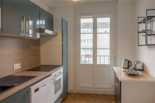 uma cozinha com uma porta branca e uma janela em Le Chancelier *T2* em Orléans