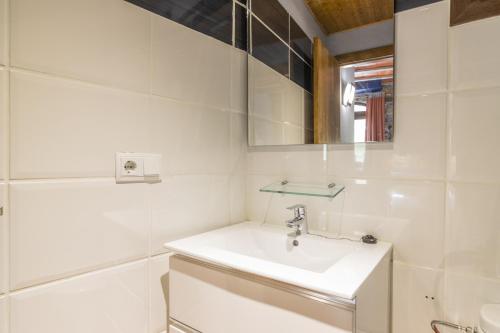 a white bathroom with a sink and a mirror at Mossen Batista Faig in Les Iglésies