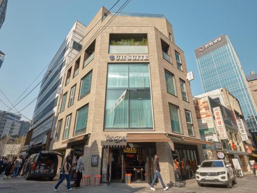 a building on a street with people walking in front of it at UH Suite Seoul Square in Seoul