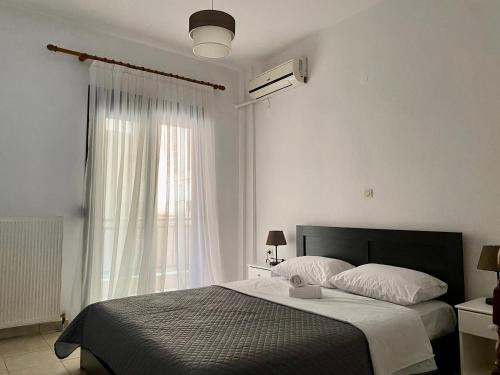 um quarto com uma cama e uma grande janela em Traveller's home em Litochoro