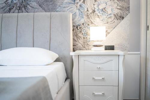 a bedroom with a bed and a nightstand with a lamp at B&B Golden House & spa in Rose