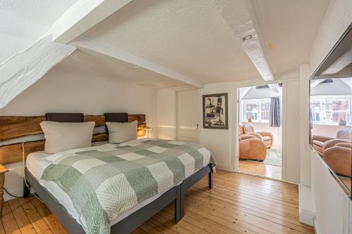 una camera con un letto con una coperta verde e bianca di fewo1846 - Dampfer Alexandra - urige Wohnung mit zwei Schlafzimmern am Nordermarkt im Stadtzentrum a Flensburgo