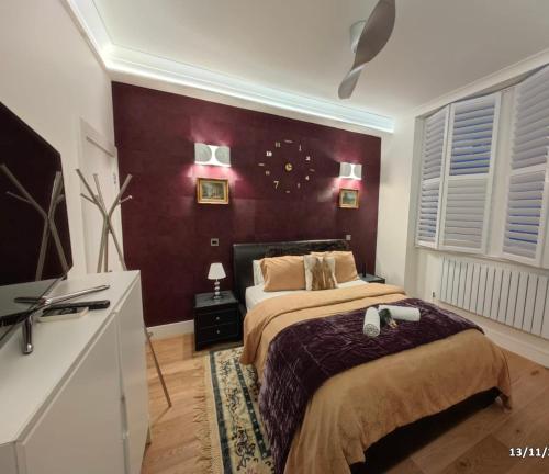 The GG Spot in South Kensington Central London 2 Bedroom Apartment by Wild Boutique Apartments في لندن: غرفة نوم بسرير كبير وبجدران حمراء
