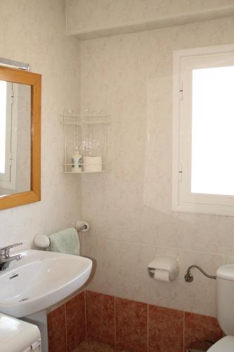 uma casa de banho com um lavatório, um WC e uma janela. em Apartamento vacacional Jávea em Xàbia