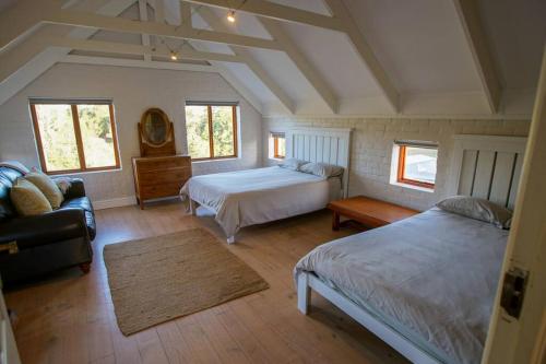 1 dormitorio grande con 2 camas y sofá en Valley Farm Stay, en Knysna