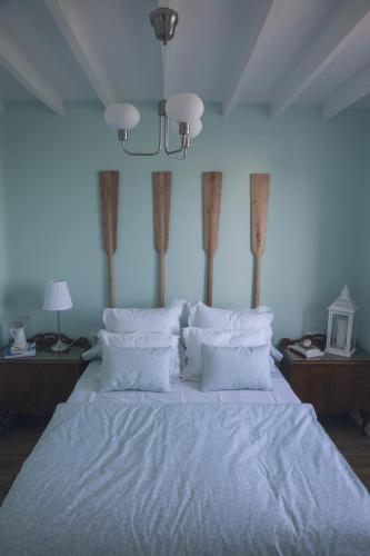 a bedroom with a bed with white sheets and pillows at A Casa do Porto in Burela de Cabo