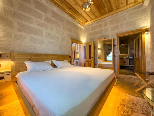 - une chambre avec un grand lit blanc dans l'établissement Konak Ballıca - Deluxe Suite, à Avanos