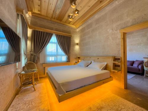 a bedroom with a bed and a couch in a room at Konak Ballıca - Deluxe Suite in Avanos