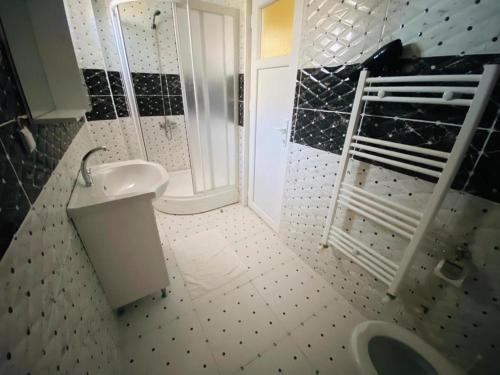 ein Badezimmer mit einem weißen Waschbecken und einer Dusche in der Unterkunft Villa Grau in Antalya/Belek in Belek