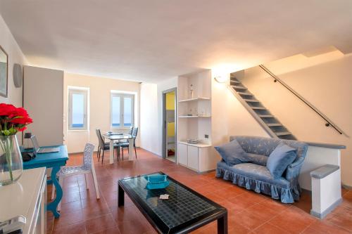 ein Wohnzimmer mit einem Sofa und einem Tisch in der Unterkunft Panoramic Bastioni Sea View in Alghero