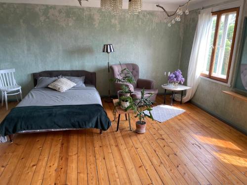 een slaapkamer met een bed en een houten vloer bij Katrina Summer House in Jūrmalciems