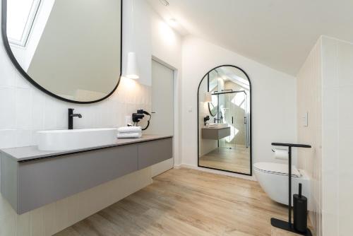 La salle de bains est pourvue d'un lavabo et d'un miroir. dans l'établissement Mielnovo - dom z basenem, sauną i jacuzzi, à Mielno