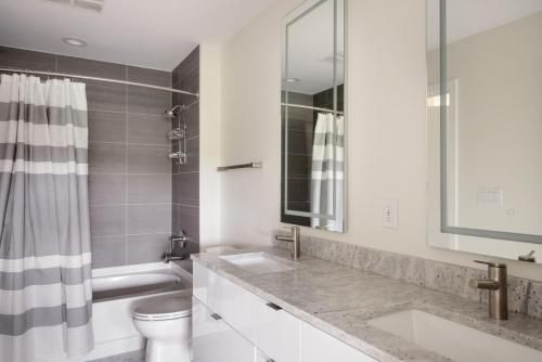 a white bathroom with two sinks and a toilet at Pentagon City 1br w pool gym nr downtown WDC-696 in Arlington