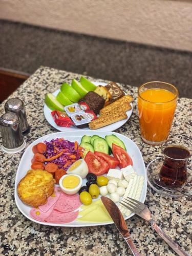 two plates of food on a table with orange juice at Maduro Hotel Istanbul in Istanbul
