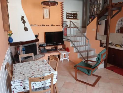 uma sala de estar com uma escada e uma televisão em Le meridiane em Piè la Costa