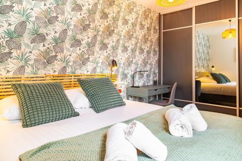 une chambre d'hôtel avec deux lits avec des serviettes dessus dans l'établissement Le Congrès- Au cœur du centre ville avec Parking, à Nantes