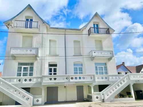 a white building with balconies on top of it at Appartement vue mer Merlimont in Merlimont