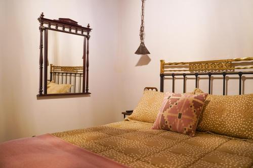 a bedroom with a bed and a mirror at La casa de la tía Antonia in Arenas de San Pedro