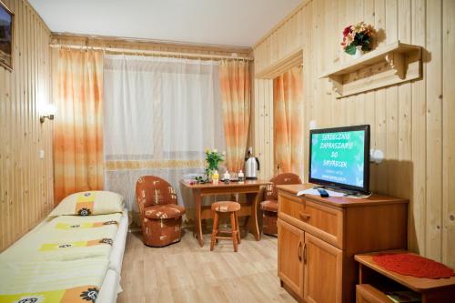 Cette petite chambre comprend un lit et une télévision. dans l'établissement Smyrecek-centrum Bukowiny, à Bukowina Tatrzańska