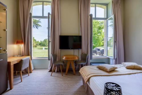 Cette chambre comprend deux lits, un bureau et une télévision. dans l'établissement Hôtel et SPA du Château, à Lagord