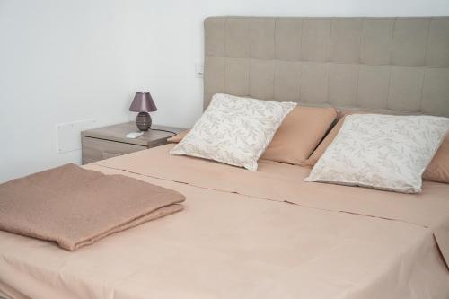 a bed with two pillows and a lamp on a table at La Casa di Sossy in Civitanova Marche