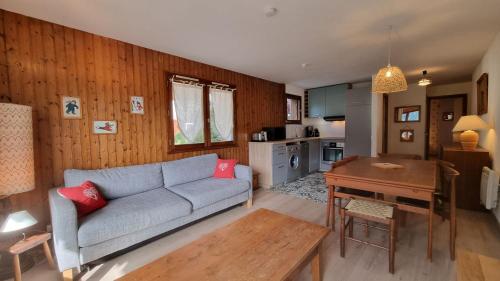 un salon avec un canapé et une table dans l'établissement Appartement Érable, au Grand-Bornand