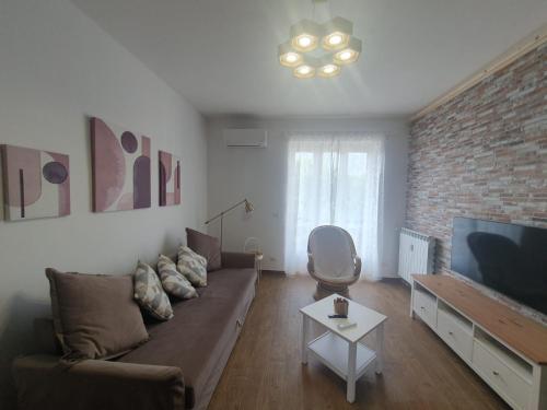 sala de estar con sofá y pared de ladrillo en Casa eNNe, Appartamento Vicino Centro e Juventus Stadium en Turín