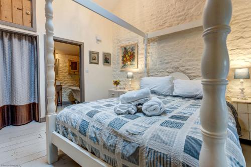 a bedroom with a bed with towels on it at The Hayloft in Hook Norton