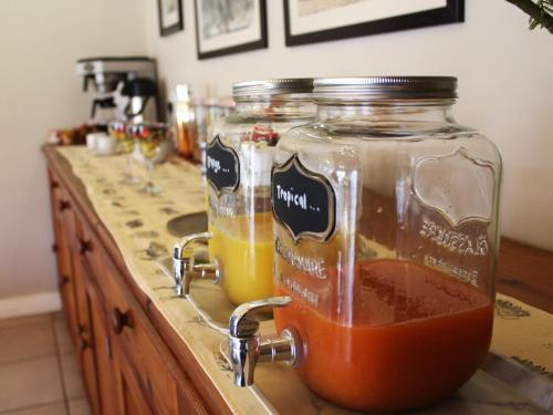 two glass jars of liquid on a kitchen counter at Bydand B&B in Addo