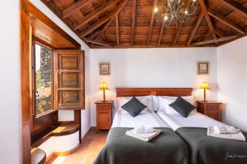 1 dormitorio con cama y lámpara de araña en Lightbooking La Morita Villa de Mazo con piscina, en Mazo