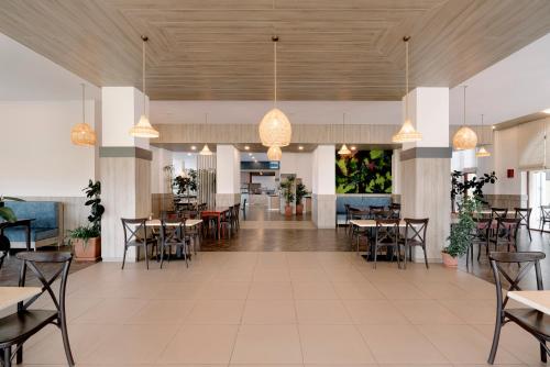 a dining room with tables and chairs and lights at Alua Helios Bay - All Inclusive in Obzor