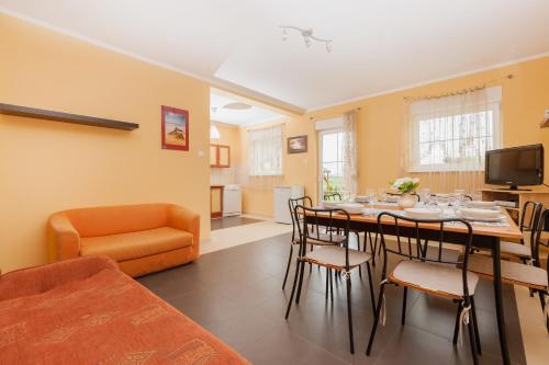 a living room with a dining room table with chairs at Holiday House Neptun by Renters in Kołczewo