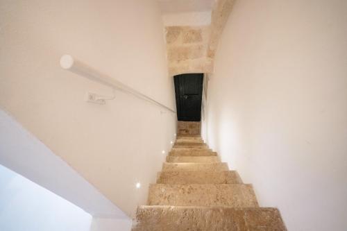 een trap in een wit gebouw met een trap bij WePuglia - Dimora Elia in Polignano a Mare
