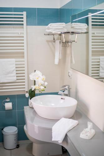 a bathroom with a sink and a toilet and a mirror at B&B Golden House & spa in Rose