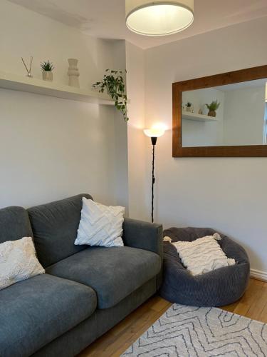 a living room with a blue couch and a lamp at Homely 2 Story Cathedral City Apartment in Durham