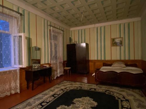 um quarto com uma cama, uma mesa e uma janela em Hotel Grand em Sagarejo